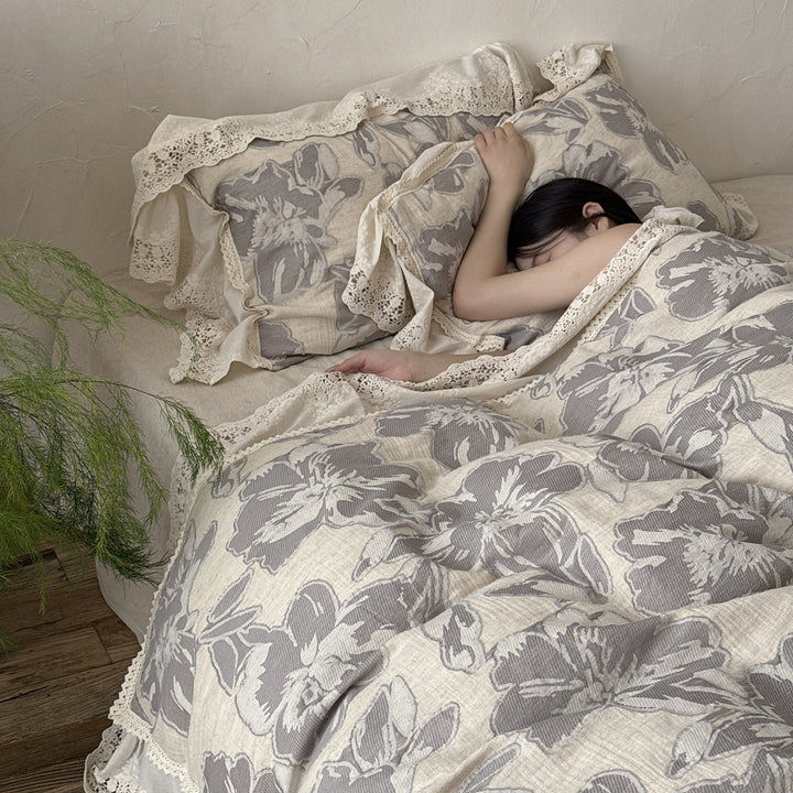 Lightly quilted cotton bedding set in country house style with lace ruffle and large floral motif