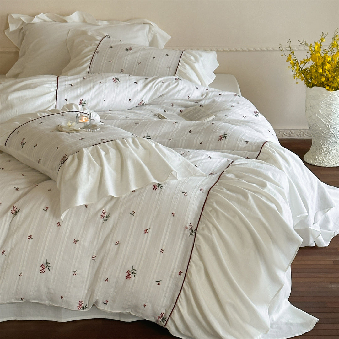 Cotton muslin bedding set with embroidered striped relief, gathered ruffle and fine piping