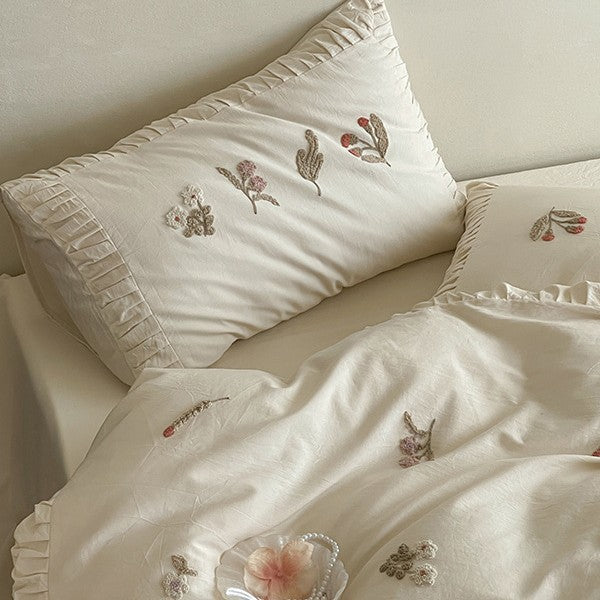 Cotton bedding set with delicate floral embroidery and ruffled edge