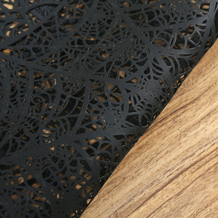 Flexible spiderweb table mat made of heat-resistant silicone as a placemat and decorative coaster with spider relief