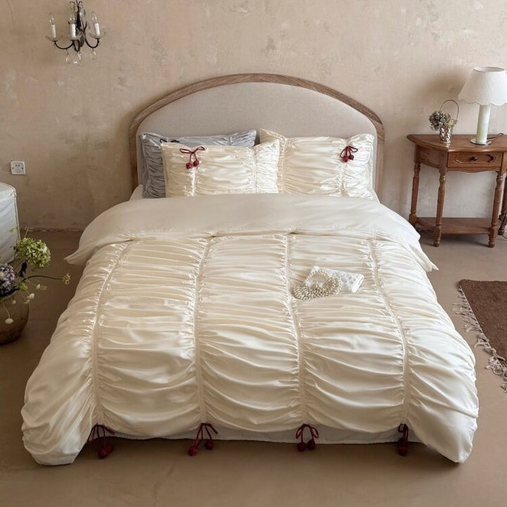 Satin bedding set with gathered drawstring look and tassels