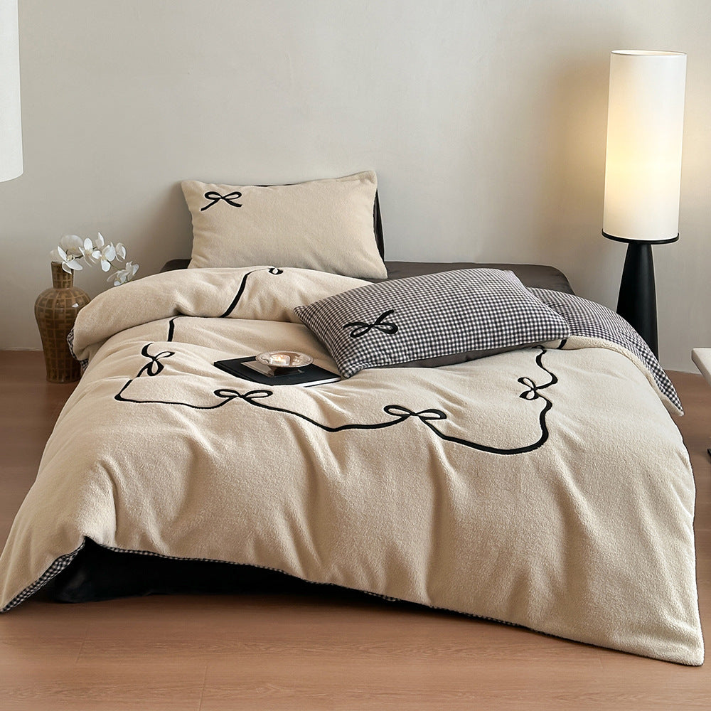 Reversible microfiber bedding set with plush surface, pom-pom corners, and paw embroidery