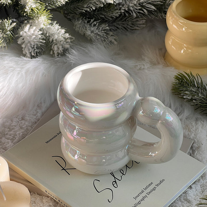 Sculptural ceramic mug with iridescent glaze and curved ring handle