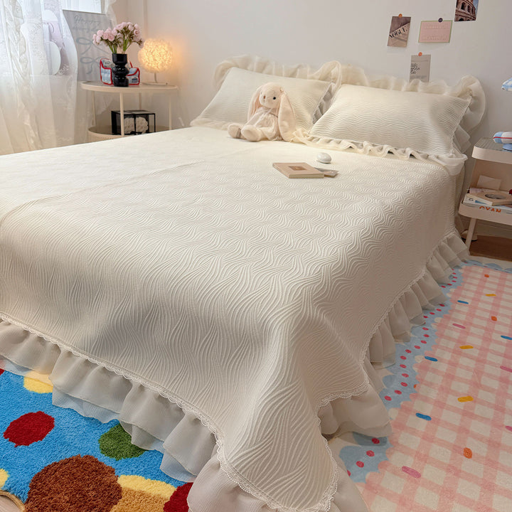 Quilted bedspread with ruffle and delicate floral quilting