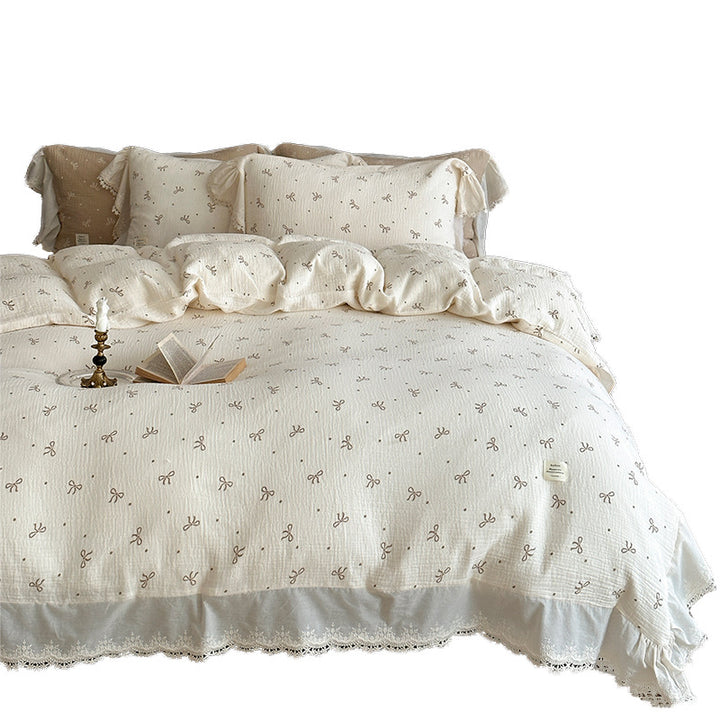 Cotton muslin bedding set with ruffles, lace trim, and delicate bow print
