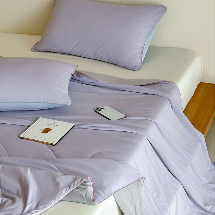 Elegant bedding set made of cotton satin with contrasting piping and light quilted blanket