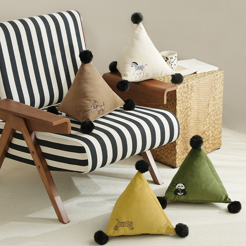 Pyramid-shaped triangle cushion with faux fur pom-poms and zebra embroidery