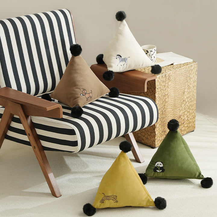 Pyramid-shaped triangle cushion with faux fur pom-poms and zebra embroidery