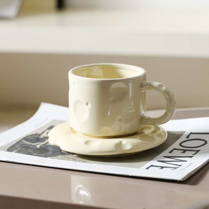 Sculptural ceramic cup set with flowing glaze and textured saucer