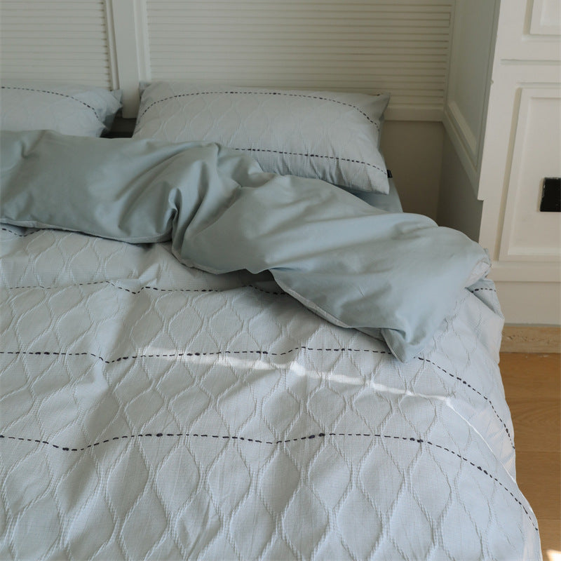 Reversible quilted bedding set made of cotton blend with textured leaf quilting and satin finish back