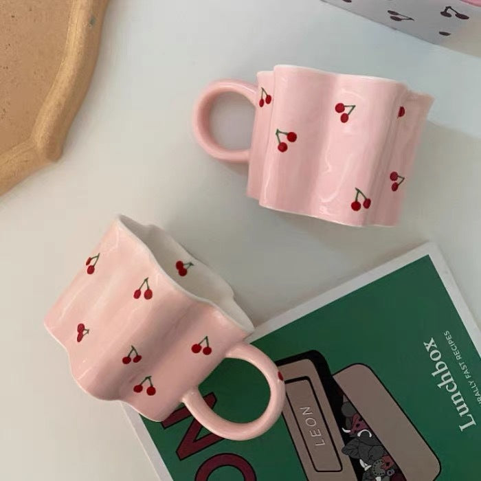 Ceramic coffee mug with flower-shaped wavy rim, illustrative banana decor and ergonomic handle