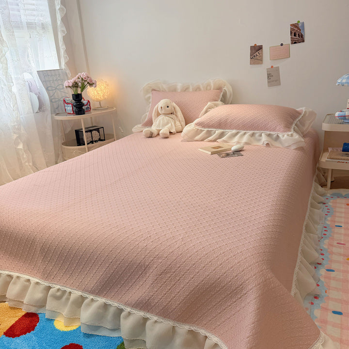 Quilted bedspread with ruffle and delicate floral quilting
