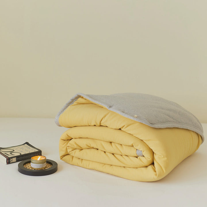 Ultralight climate-regulating quilted blanket with compact filling and cotton surface