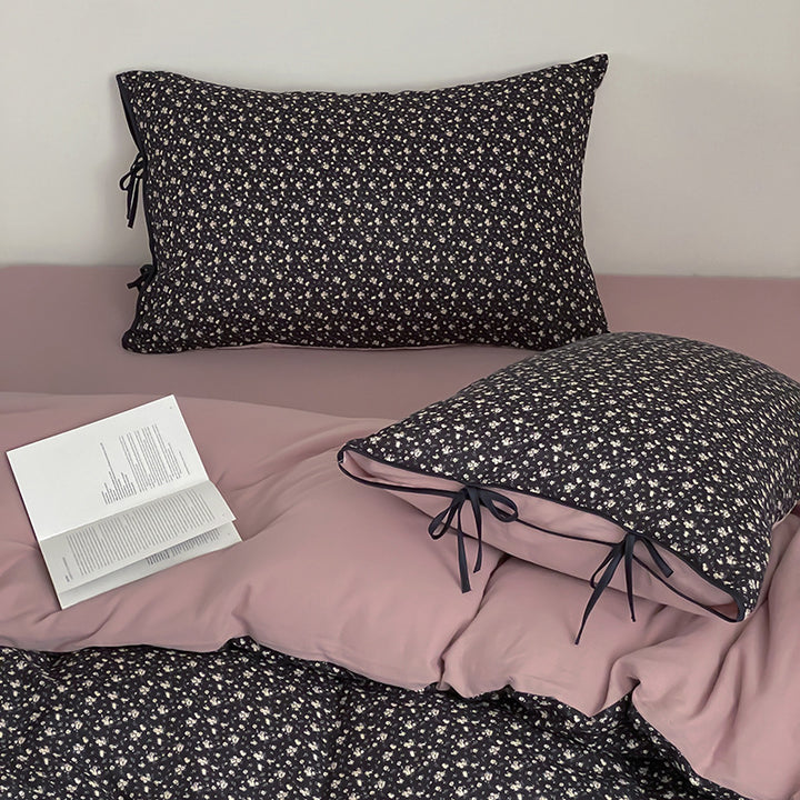 Reversible bedding set made of cotton satin with a fine floral allover, contrasted inside and decorative ribbons.