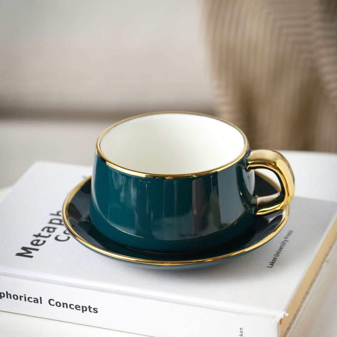 Elegant porcelain cup with saucer and sculptural gold handle