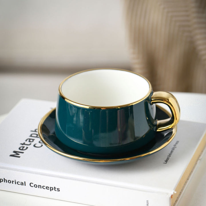 Elegant porcelain cup with saucer and sculptural gold handle