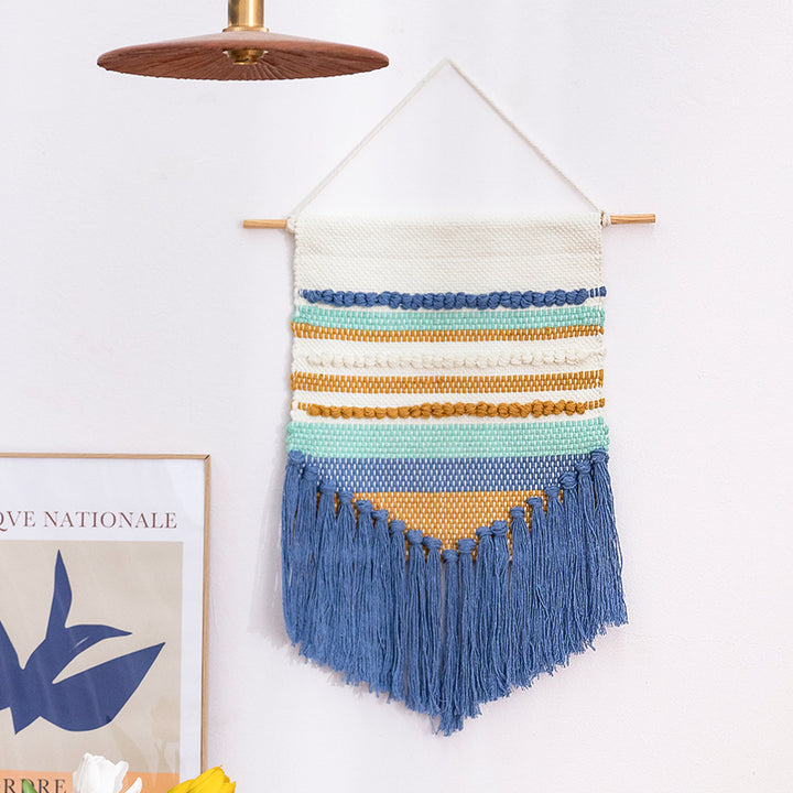Handwoven wall hanging in boho style with tassels and geometric structure