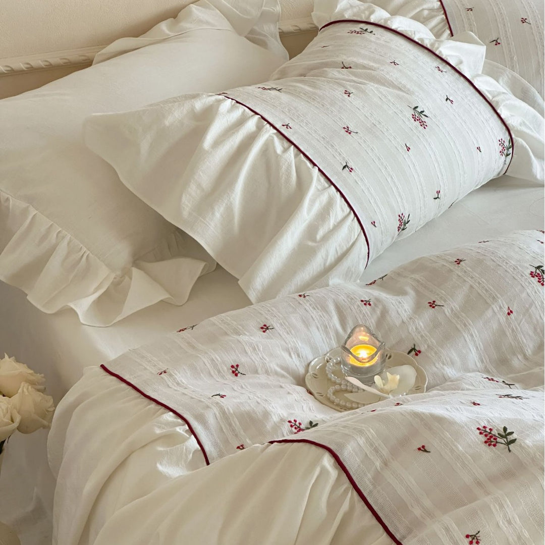 Romantic bed linen set made of cotton satin with ruffles, relief stripes, and contrasting piping