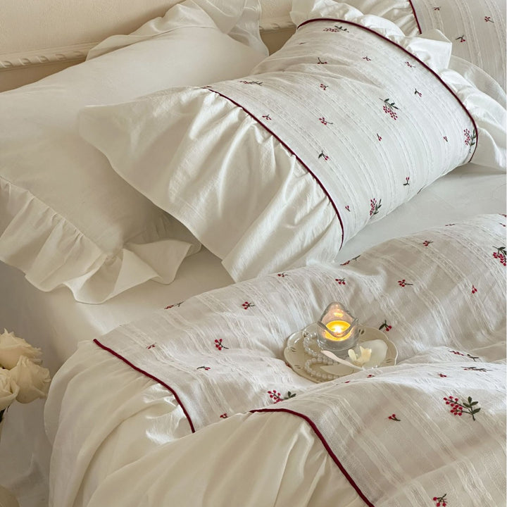 Romantic bed linen set made of cotton satin with ruffles, relief stripes, and contrasting piping