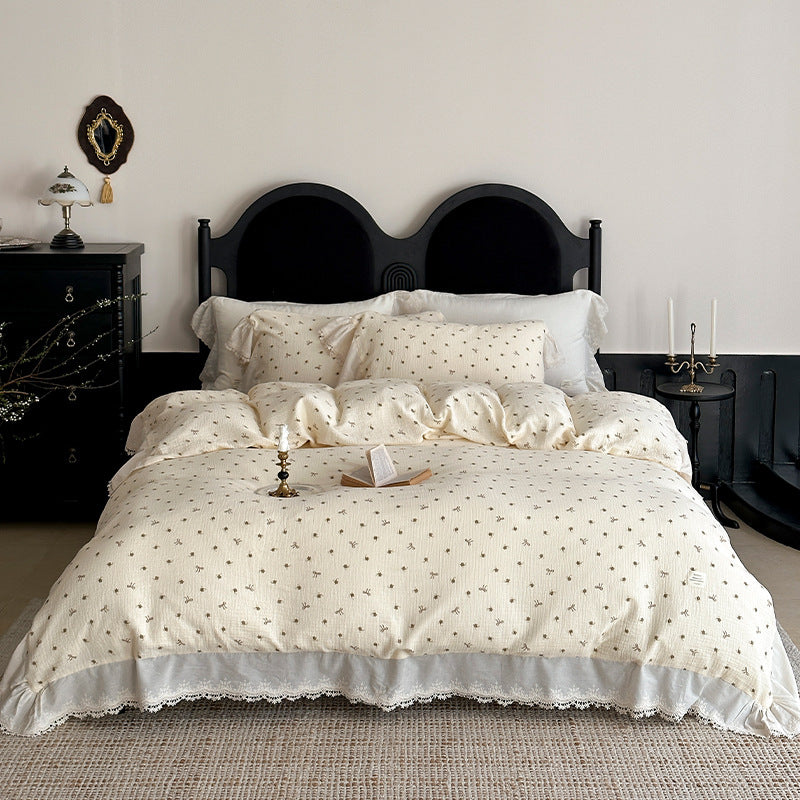 Cotton muslin bedding set with ruffles, lace trim, and delicate bow print