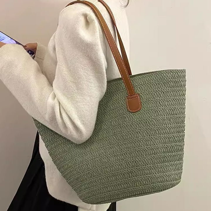 Stylish beach bag made of woven natural material with leather handles Kalsten