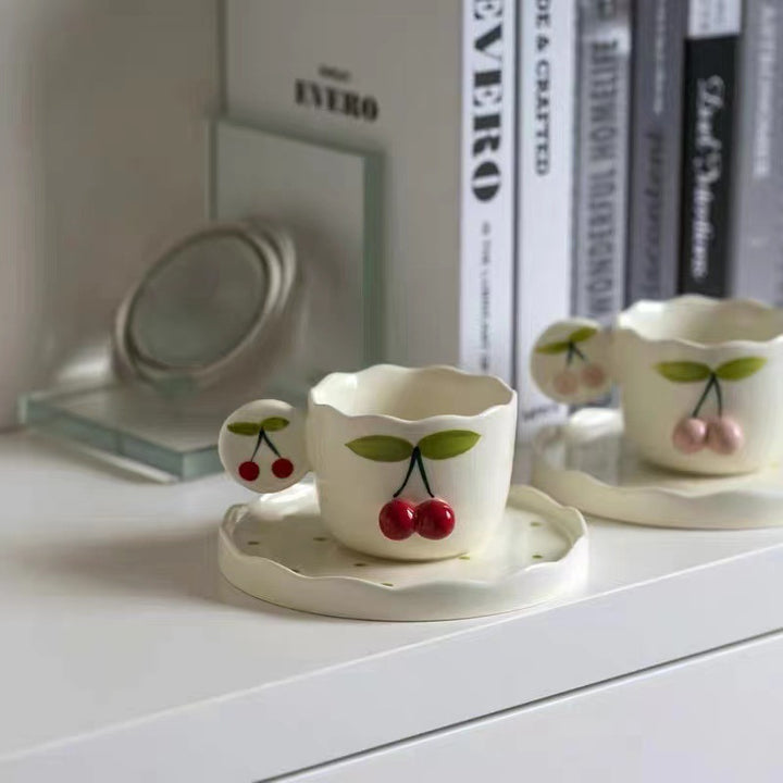 Hand-shaped espresso cup with wavy edge, round handle plate and applied cherry relief