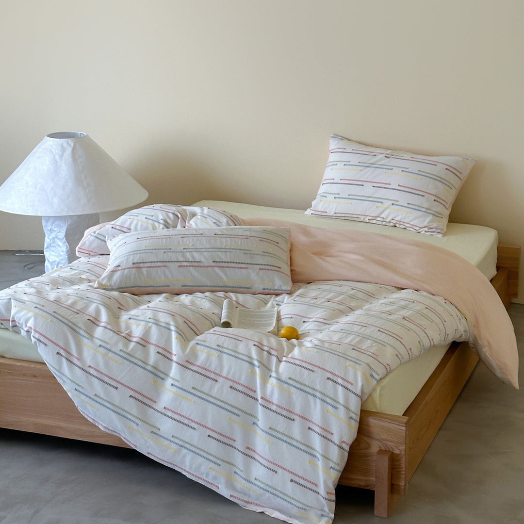 Bedding set made of cotton percale with subtle stripe and pompom design