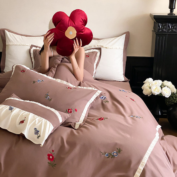 Duvet cover set made of premium cotton satin with subtly embroidered wildflower motif and ruffle edge