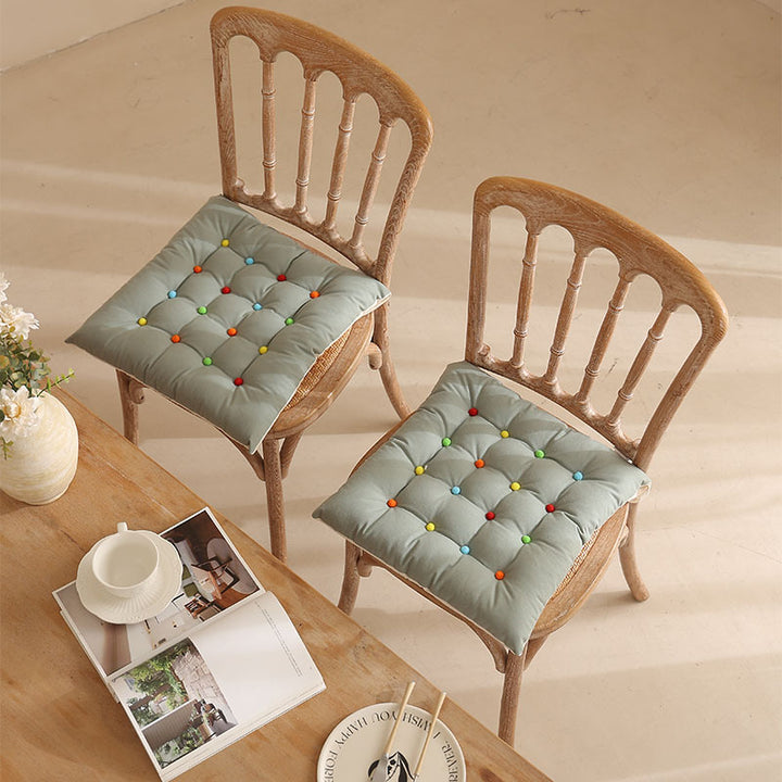 Padded quilted seat cushion with colorful button applications and non-slip underside Kalsten