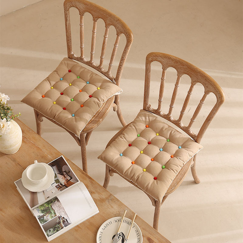Padded quilted seat cushion with colorful button applications and non-slip underside Kalsten