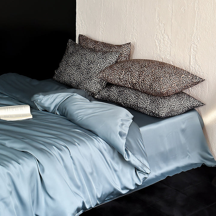 Satin bedding set with a silky sheen, smooth drape, and animal print pillows
