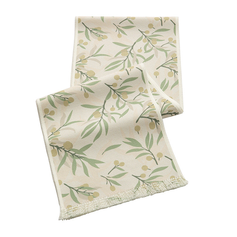 Woven botanical table runner with olive branch motif and fringed edge