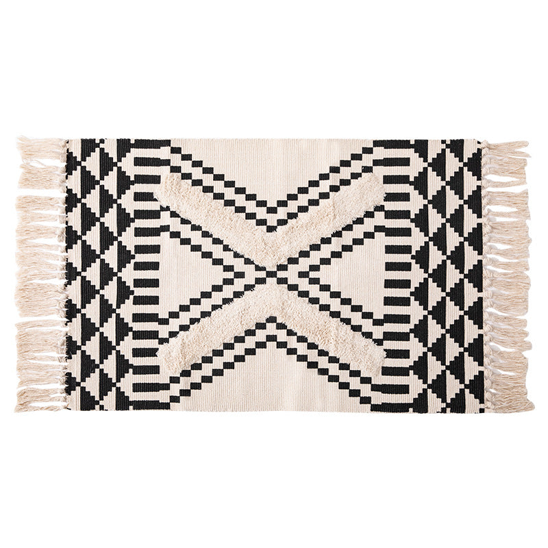 Hand-tufted bathroom mat with fringes, decorative dot-and-dash pattern and non-slip backing Kalsten