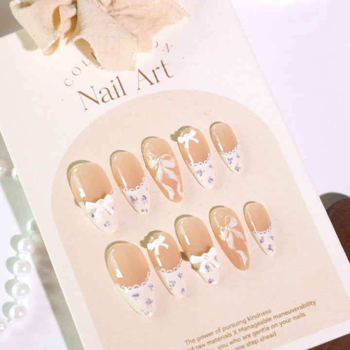 Artful nail art with elegant bows and rhinestone details Kalsten