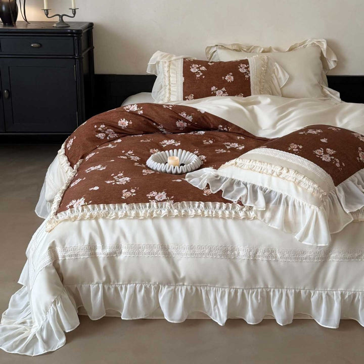 Luxury bedding set made of cotton satin with a ruffled bed skirt, lace trim, and quilted vintage blanket