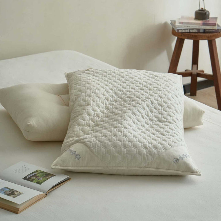 Ergonomic pillow with split filling of buckwheat shells and polyester fibers