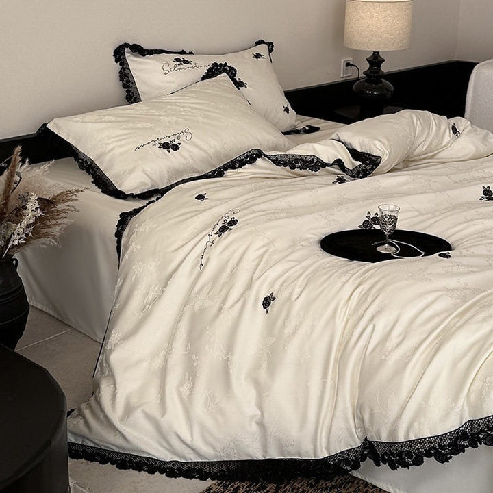 Luxurious satin bedding set with black lace trim and embroidered rose appliqués