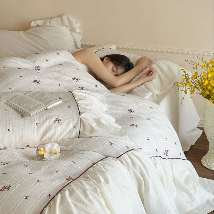 Romantic bed linen set made of cotton satin with ruffles, relief stripes, and contrasting piping