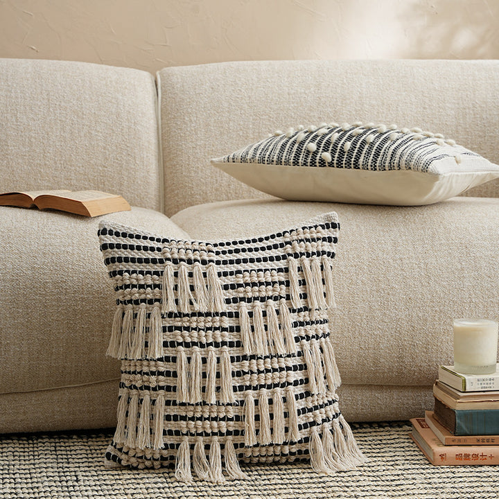 Square woven decorative pillow cover with tiered tassels and textured cotton surface