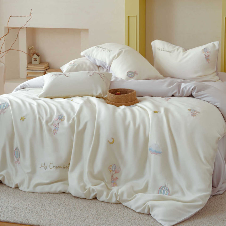 Premium children's bedding set made of cotton satin with pastel-embroidered balloon and carousel motifs.