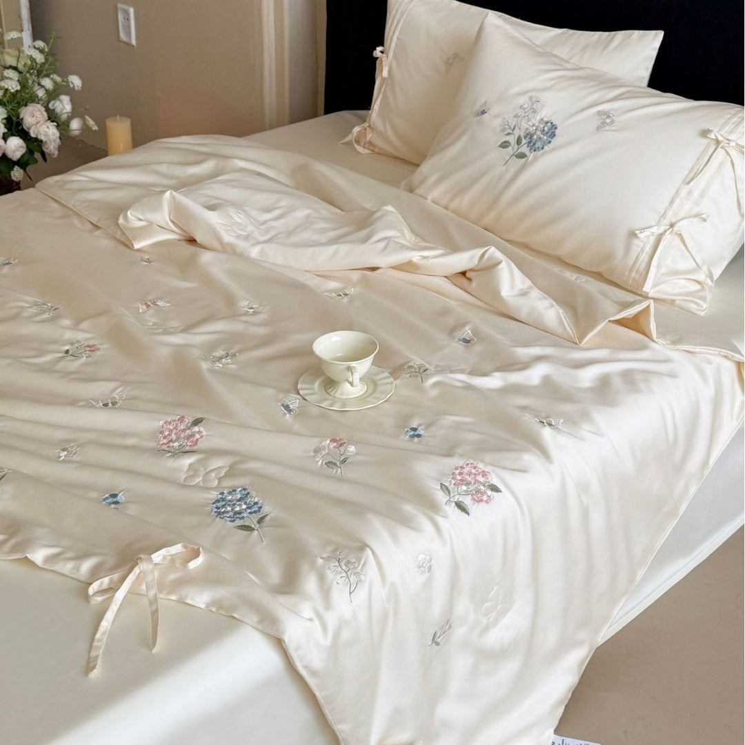 Satin bedding set with floral embroidery, tie ribbons, and silky glossy finish
