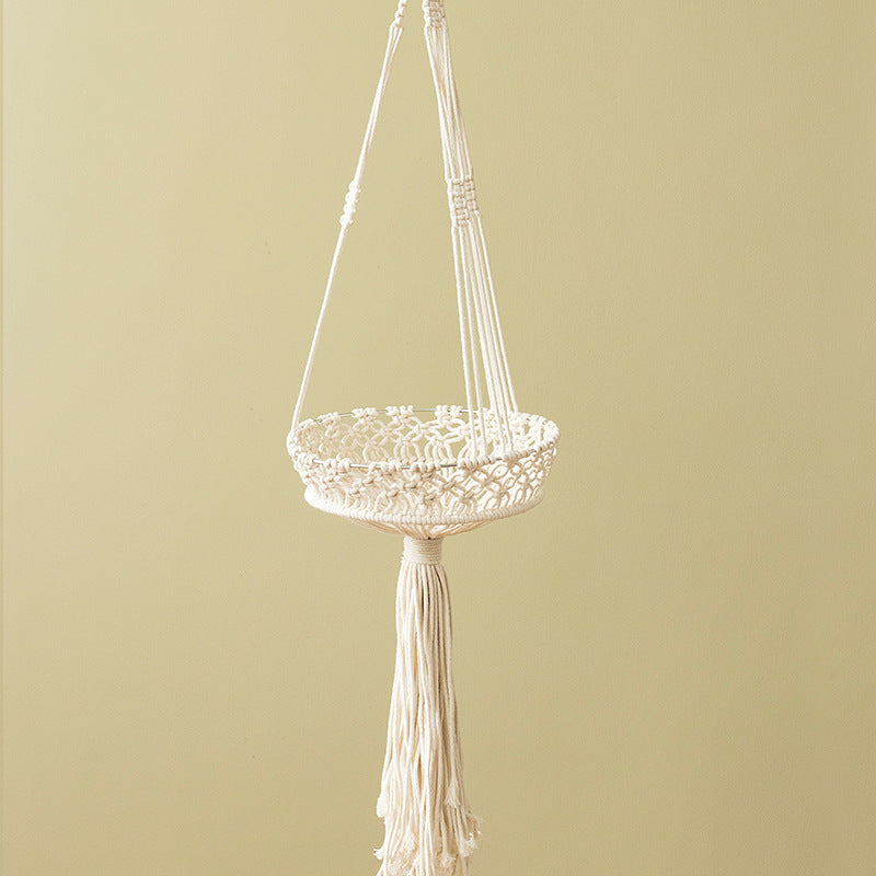 Macramé hanging planter with hand-knotted basket structure and decorative tassel