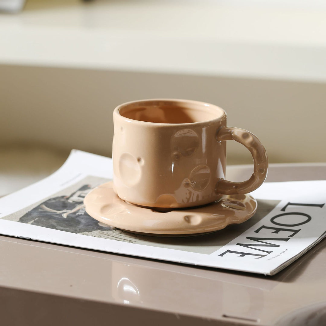 Sculptural ceramic cup set with flowing glaze and textured saucer