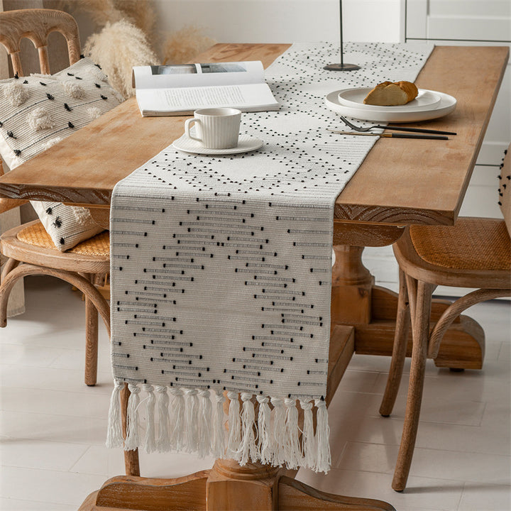 Woven table runner with geometric polka dot pattern, hand-fringed edge and sturdy cotton blend