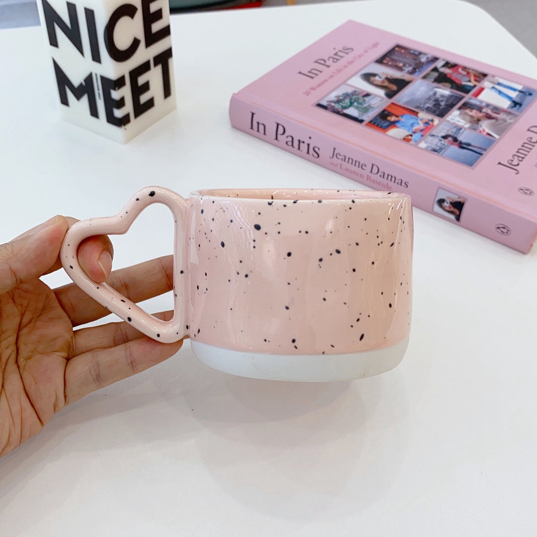 Ceramic mug with heart-shaped handle and speckle design