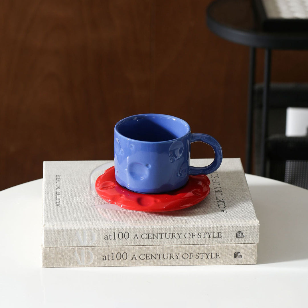 Ceramic coffee cup set with textured relief surface and wavy saucer