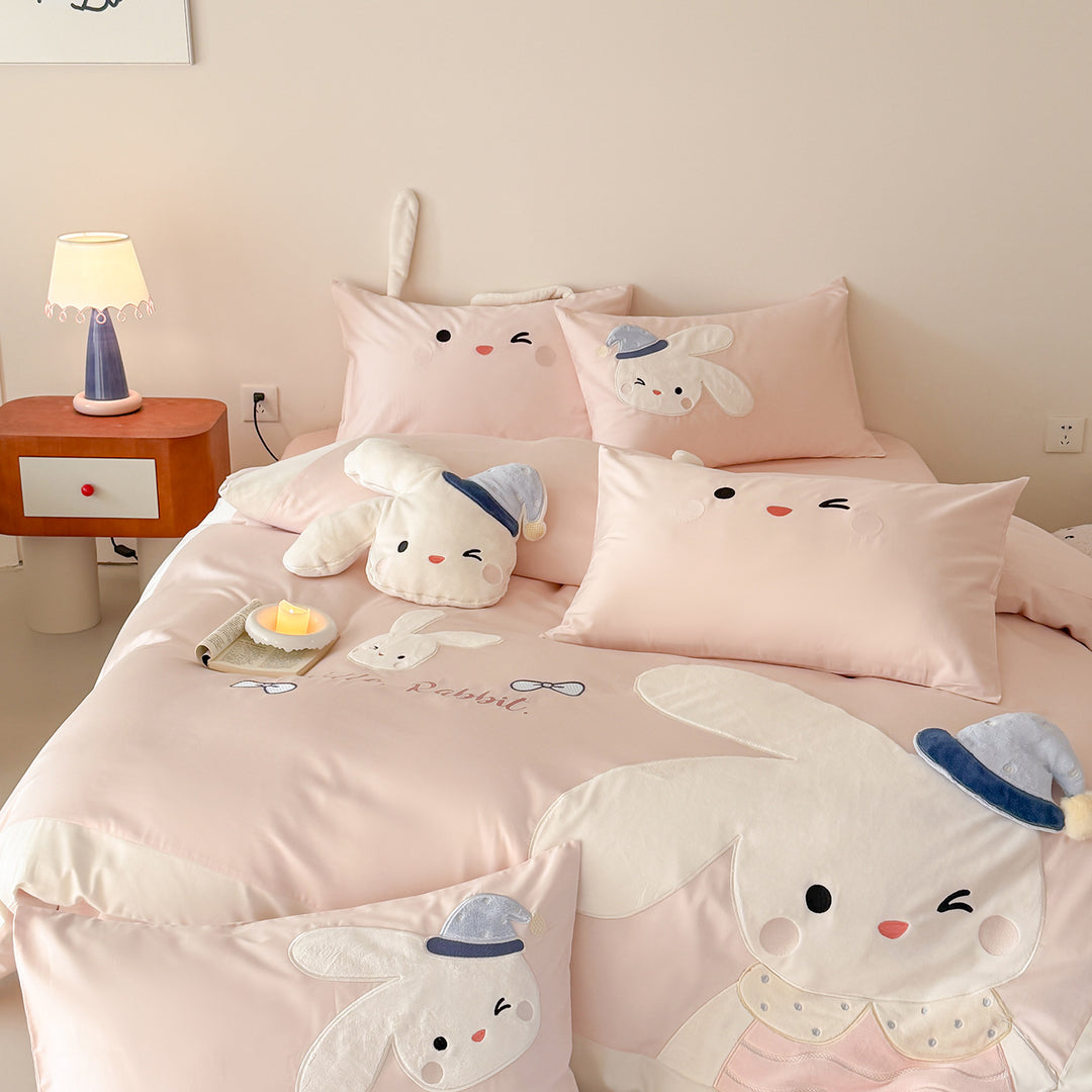 Children's bedding set with three-dimensional ears, plush pillow, and embroidered rabbit appliqués