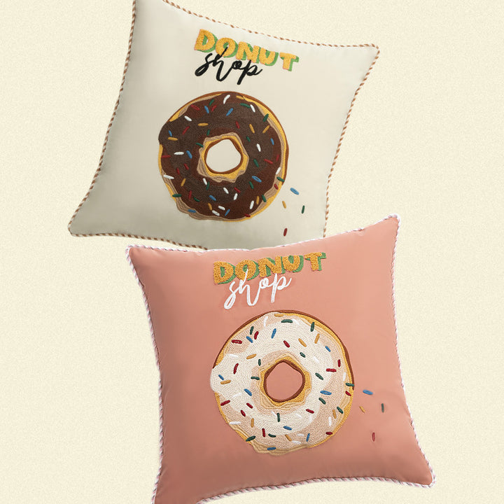 Square decorative cushion with embroidered donut motif and decorative piping edge