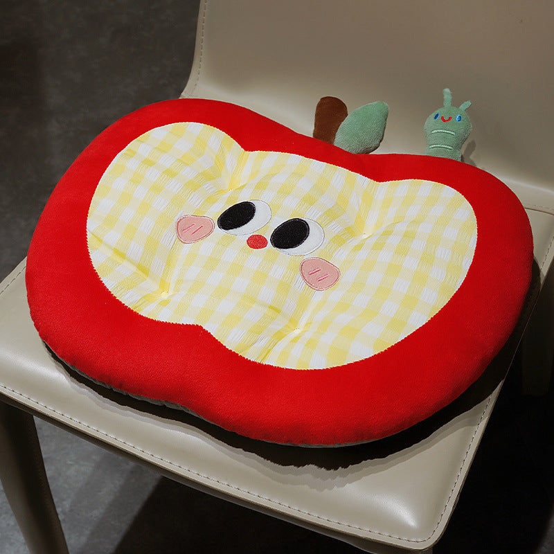 Padded children's seat cushion in apple shape with ergonomic seat recess and plush pendant