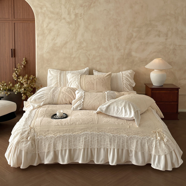 Luxury bedding set with quilted coverlet, lace ruffle, and decorative bed skirt